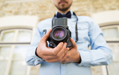 close up of hipster man with film camera in city