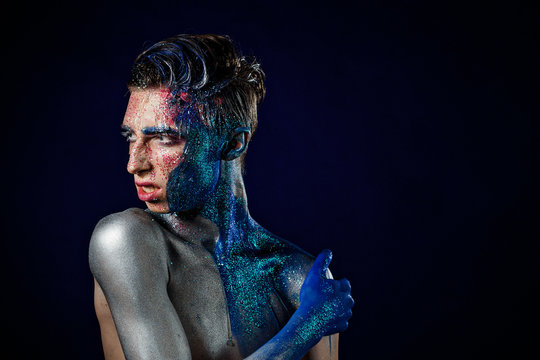 Crazy young androgyne man with face art. SPACEMAN. Freak person. Tinsel creative blue makeup. Intersex and anorexia concept. Space for logo. HOMOSEXUALITY