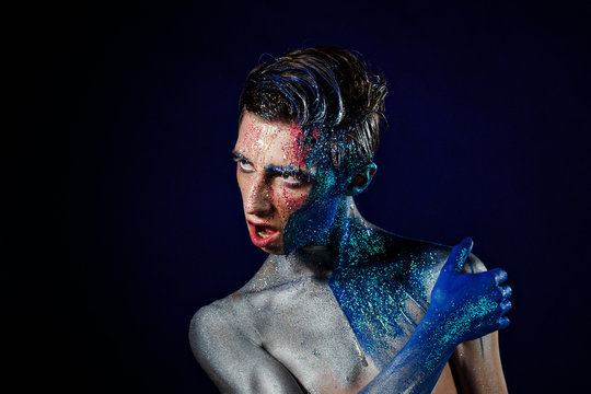Crazy young androgyne man with face art. SPACEMAN. Freak person. Tinsel creative blue makeup. Intersex and anorexia concept. Space for logo. HOMOSEXUALITY