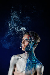 Crazy young man with face art smoking and enjoying. Freak person - 108136987