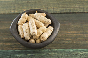 Peanuts in shells on wood background
