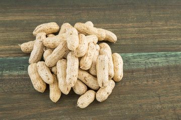 Peanuts in shells on wood background