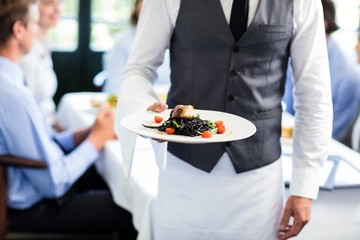 Obraz na płótnie Canvas Waiter holding a plate of meal