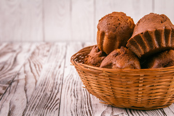 Cupcakes in a wicker breadbaskets - obrazy, fototapety, plakaty