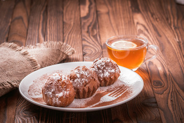 cupcakes on a plate and a cup of tea