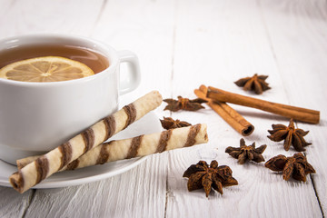 cup of tea with lemon, biscuits and spices