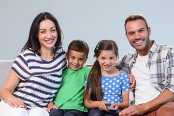 Happy young family watching television with their two children