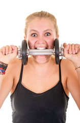 Junge Frau beisst in Fitness Hantel