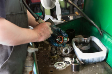 Mechanic repairing electric generator, repair of starter 
