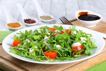 salad with tomatoes, mini mozzarella, arugula, close-up
