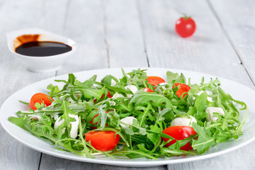 salad with tomatoes, mini mozzarella, arugula, close-up