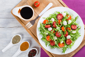 salad with tomatoes, mini mozzarella, arugula, fried sausages