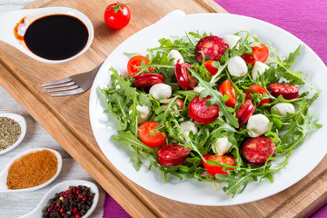 Fried sausages, tomatoes, mini mozzarella, arugula salad