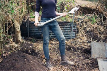 Young woman in garden with spade