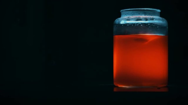 Orange Mysterious Liquid Whirl in a Glass Jar with Back Light