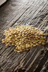 Obraz premium Brown lentils set on old wooden surface