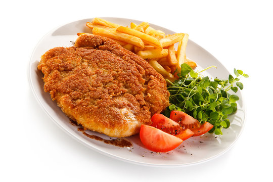 Fried pork chop, French fries and vegetables 