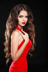 Fototapeta premium Beautiful girl with long wavy hair in red dress. Brunette with c