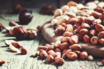 Spilled peanuts, vintage wooden dark background, selective focus