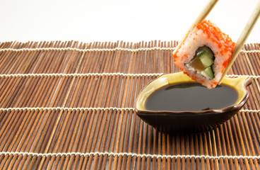 Sushi roll with salmon cucumber and cheese with chopsticks
