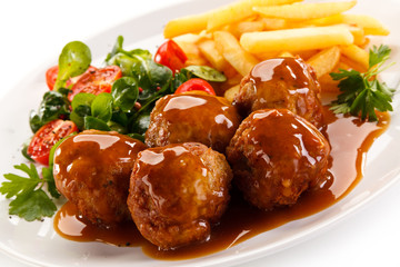 Roasted meatballs, chips and vegetables 