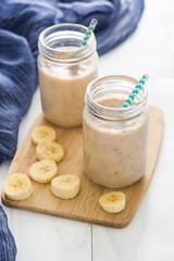Banana smoothies on white wood

