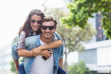 Man giving piggyback to woman