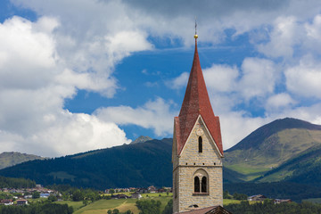Fototapeta na wymiar Italien, Südtirol, Eisacktal, Spinges, Blick zur Pfarrkirche zum Hl. Rupert mit Skiort Meransen im Hintergrund