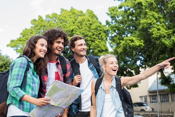 Friends holding map and pointing