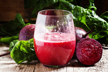 Large glasses with red beet juice, fresh beetroot with tops, vin