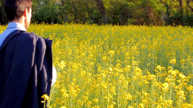 uomo d'affari lancia giacca su prato fiorito