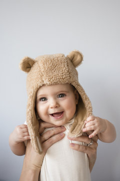 Baby daughter in fuzzy hat, held by adult