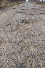 asphalt bad broken road with pits and potholes