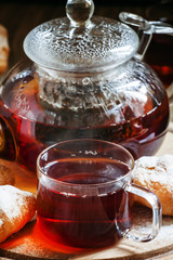 Ceylon black tea in glass cups with kettle, fresh croissants, vi