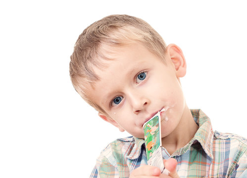 Young Child Eating Yogurt In A Tube Isolated On White 