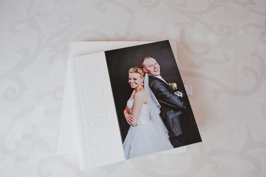 White leather wedding album with photo on canvas of newlyweds