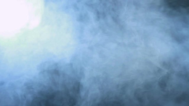 Smoke background. Abstract blue smoke cloud. Smoke in slow motion. White smoke slowly floating through space against black background. Smoke effect. Fog effect. Smoke machine. Studio shot