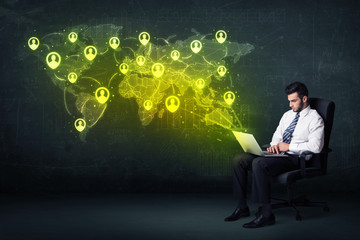 Businessman in office with laptop  and social network world map
