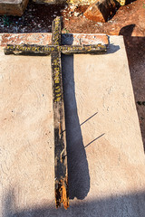 Old wooden cross lying on a grave