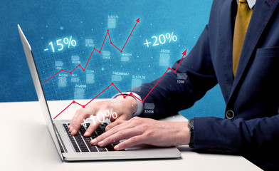 Salesman working on graph with laptop