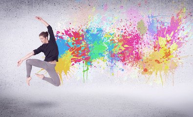 Fototapeta na wymiar Modern street dancer jumping with colorful paint splashes