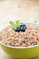 Buckwheat porridge in a bowl with mint leaves and blueberries.