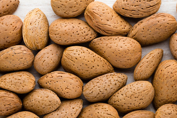 Group of almond nuts with leaves.Wooden background.