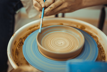 Obraz premium man paints a clay plate