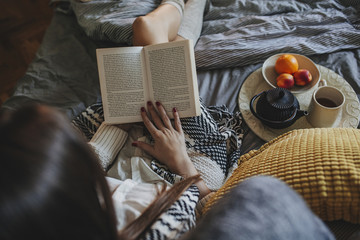 Woman reading book on bed