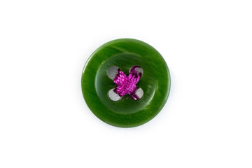 green button with pink thread on white background
