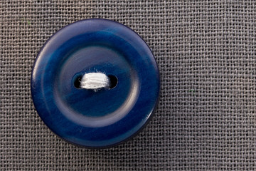 button on gray fabric in macro