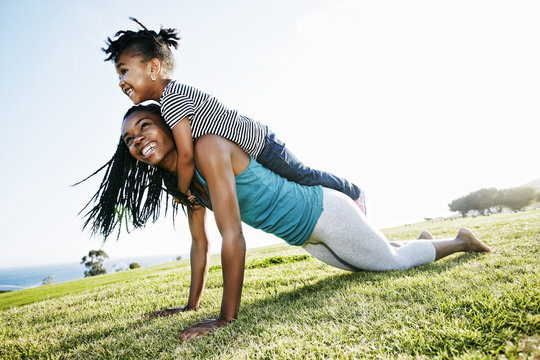 Black mother and daughter practicing yoga