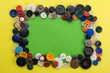 buttons and green sheet of paper on a yellow background