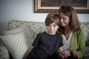 Grandmother and grandson sitting on sofa